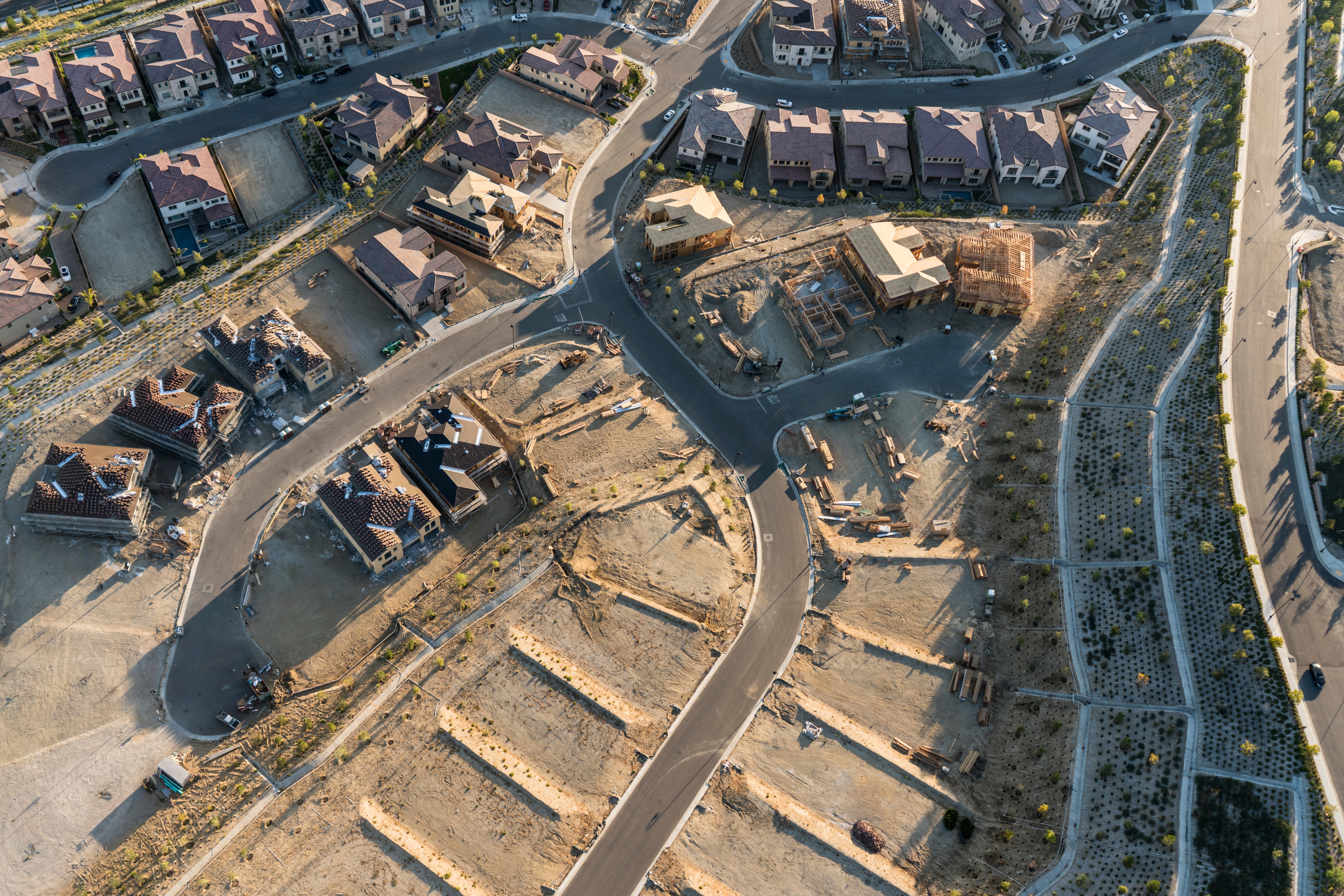 Aerial view of new housing development with graded lots and partially built homes representing homebuilder challenges with local zoning laws and subdivision approvals 