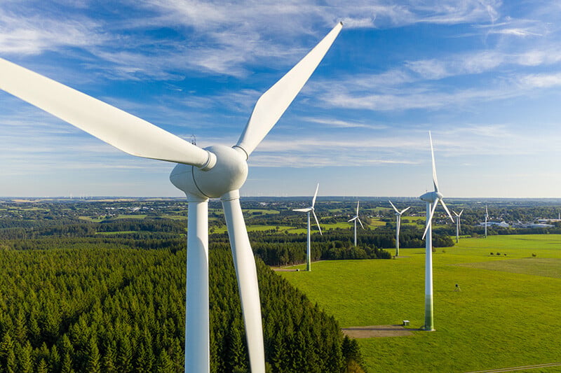 Wind turbines in an open field representing using Acres Layer Library for renewable energy project site selection.