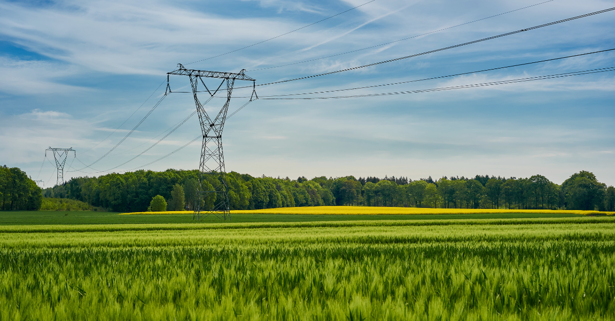 High-voltage power transmission lines across open land illustrating infrastructure proximity for data center site selection.