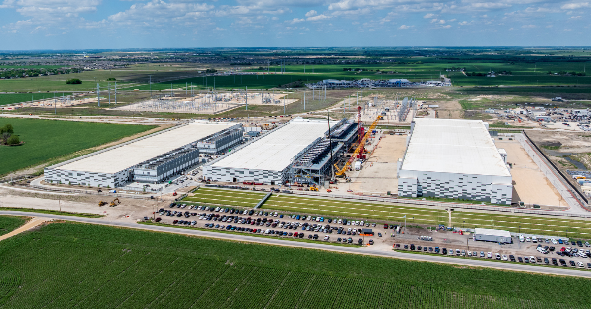 Aerial photo of an industrial data center campus under construction next to utility infrastructure, representing data center zoning requirements and land development.