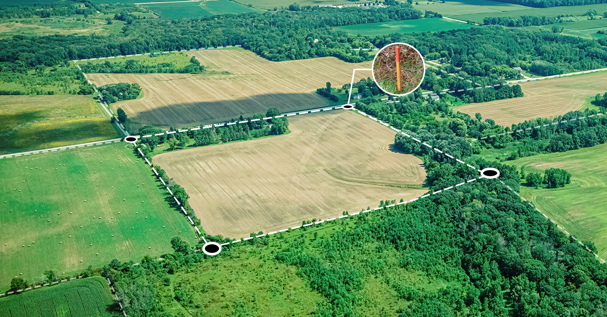Aerial photo of a rural land tract with survey markers and dashed boundary lines illustrating the legal boundaries and corner pins used to define a land parcel