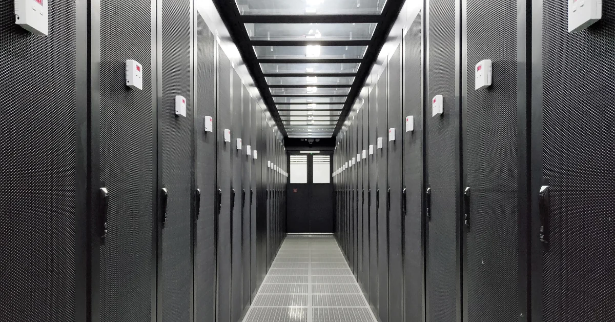 Interior of a modern wholesale colocation data center showing server rack containment corridor, representing colocation provider infrastructure and land acquisition growth.
